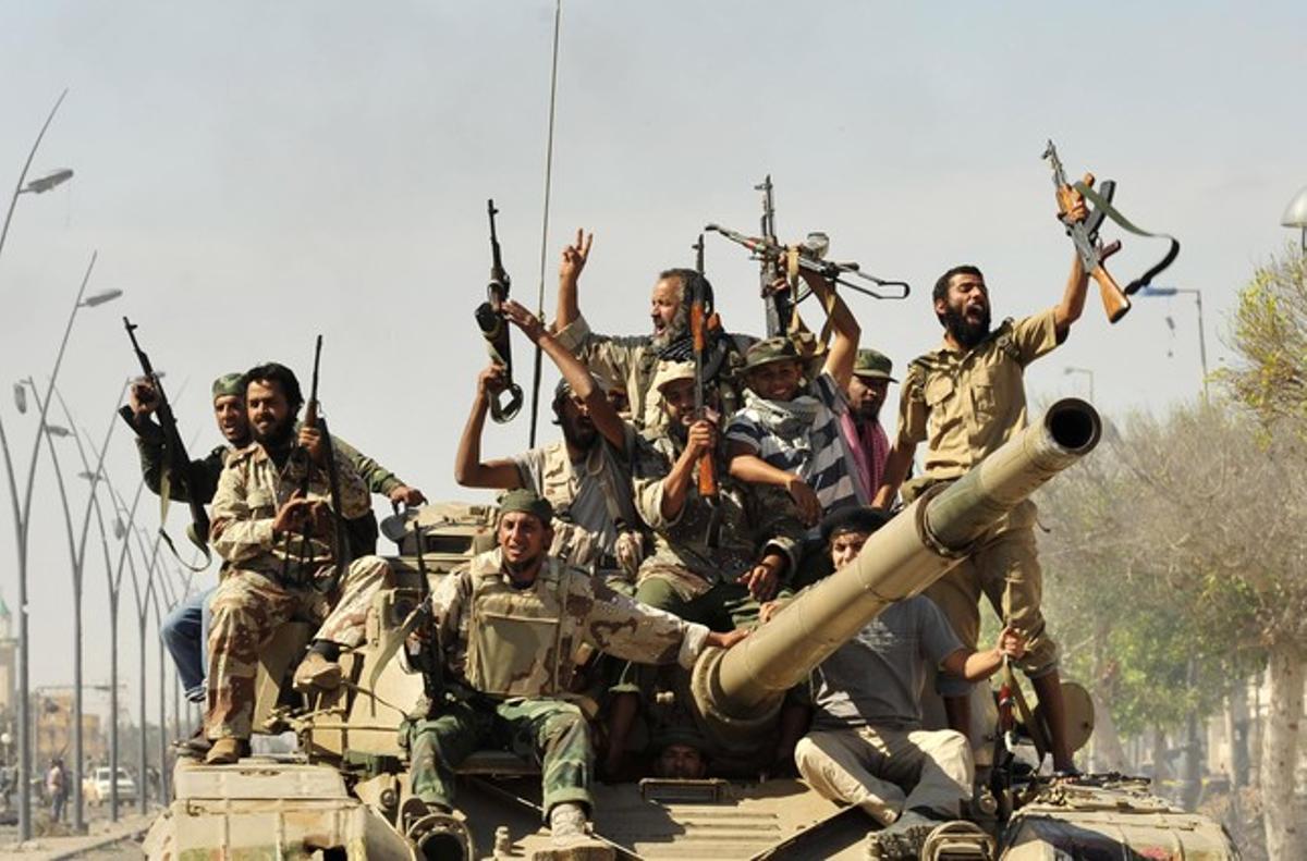 Combatents rebels celebren la caiguda del dictador libi, Muammar al-Gaddafi, a Sirte.