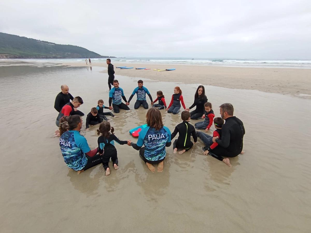 Participantes nunha sesión de surf na praia carballesa de Razo.