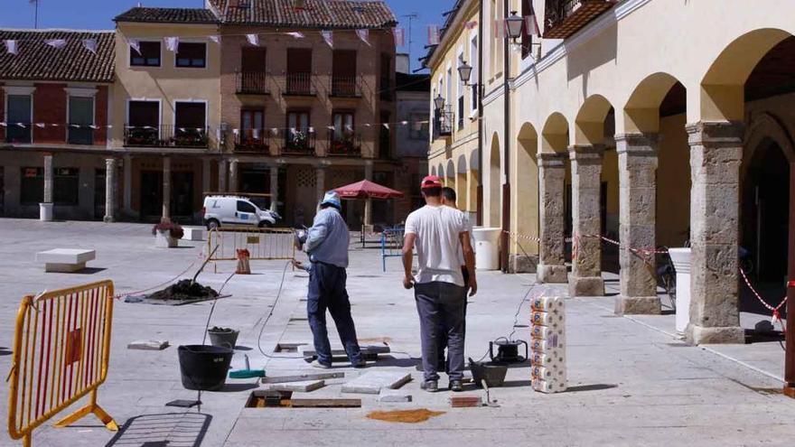 Los obreros instalando los elementos de sujeción en el pavimento de la plaza villalpandina.