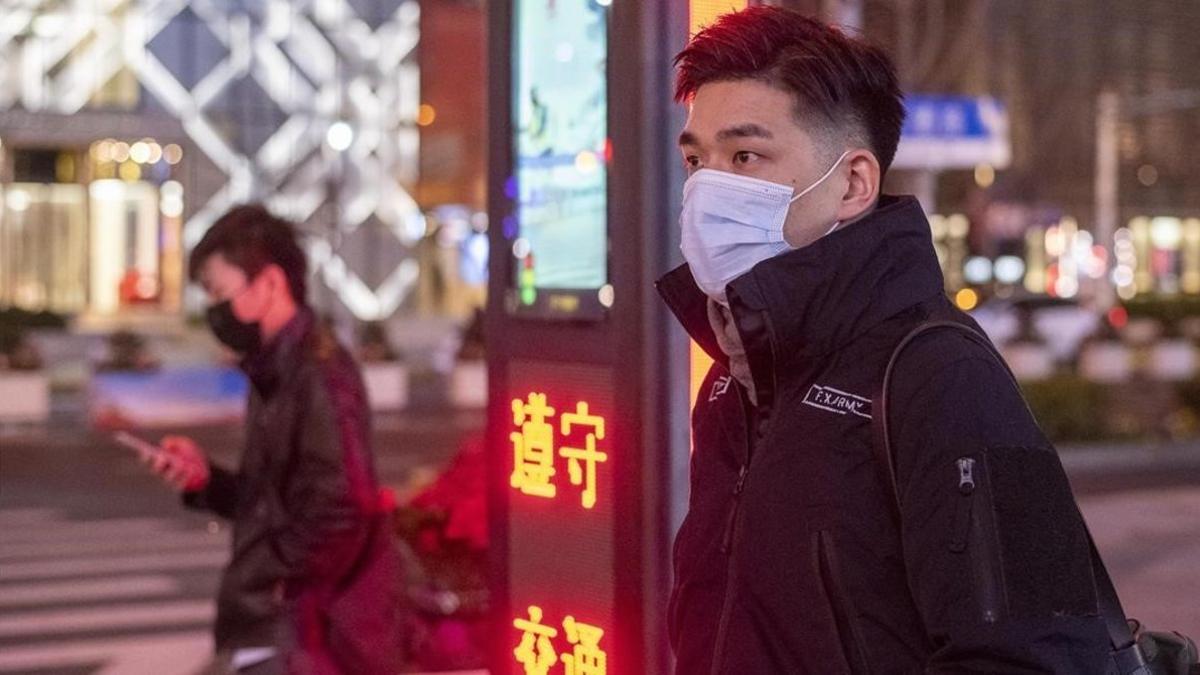 Un hombre en Shanghai con mascarilla para evitar el coronavirus.