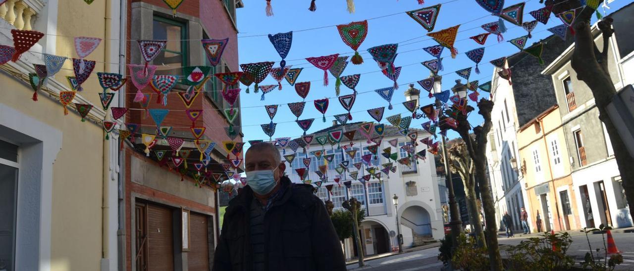 José Veiguela pasa por un tramo de calle decorado con piezas de ganchillo hechas por las mujeres de la asociación Forum Boal 3000. | A. M. Serrano