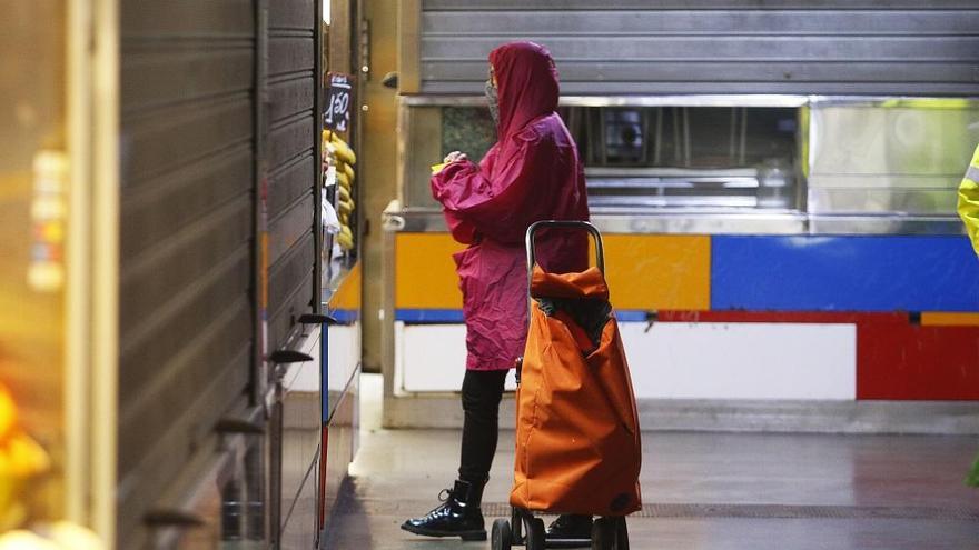 Un cliente compra en uno de los pocos puestos del Mercado de Atarazanas que permanecen abiertos.