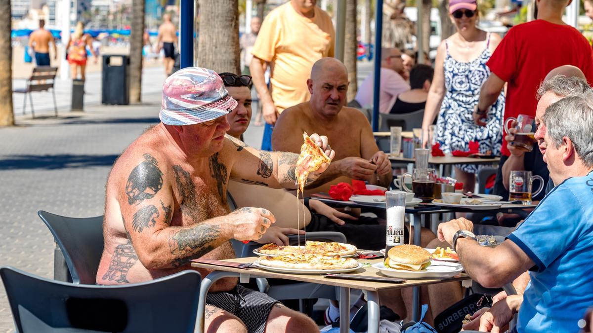 Un grupo de turistas comienzo pizza en una terraza de Benidorm