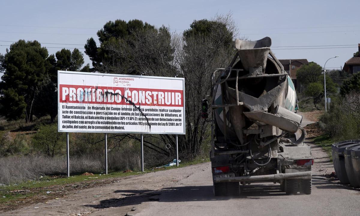 Vista de un cartel donde se advierte que está prohibido construir a la entrada de las urbanizaciones ilegales de Mejorada del Campo, en Madrid.