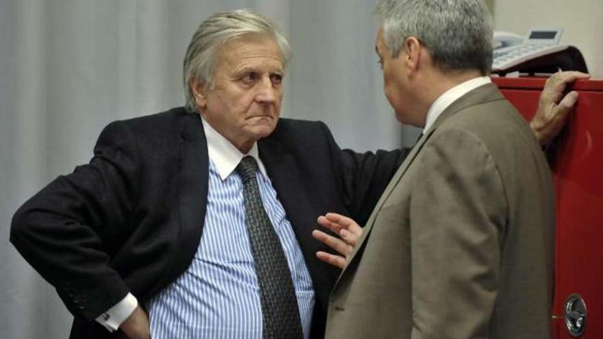 El presidente del BCE, Jean-Claude Trichet, habla con el ministro belga de Finanzas. / n. bouvy