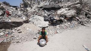 Un niño palestino junto a un edificio destruido por los bombardeos del Ejército de Israel contra la ciudad de Jan Yunis, en el sur de la Franja de Gaza (archivo)