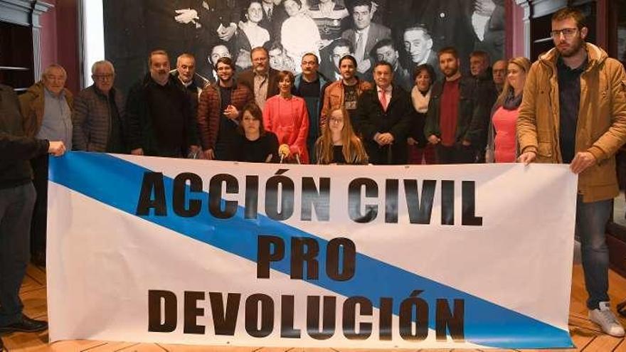 Organizadores de la marcha, ayer, muestran la pancarta con el lema de la manifestación.