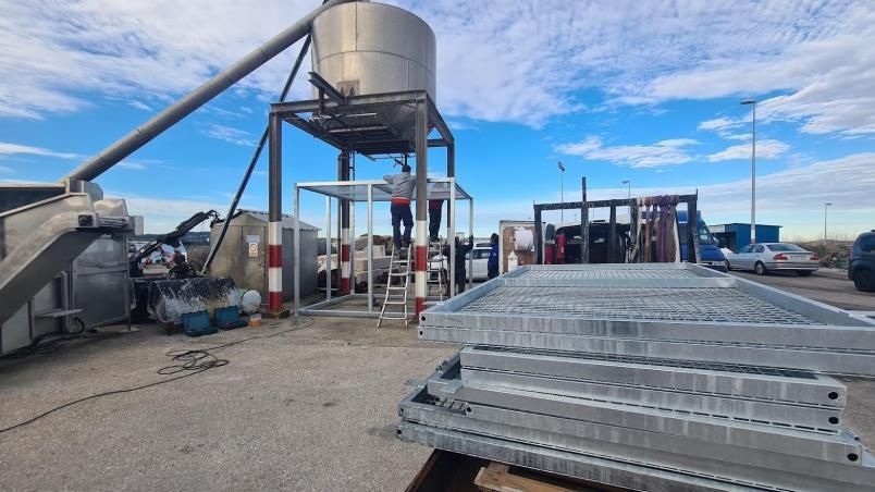 Instalación de una jaula de metal en cuyo interior depositar basura marina, justo al lado de donde está el montón de residuos.