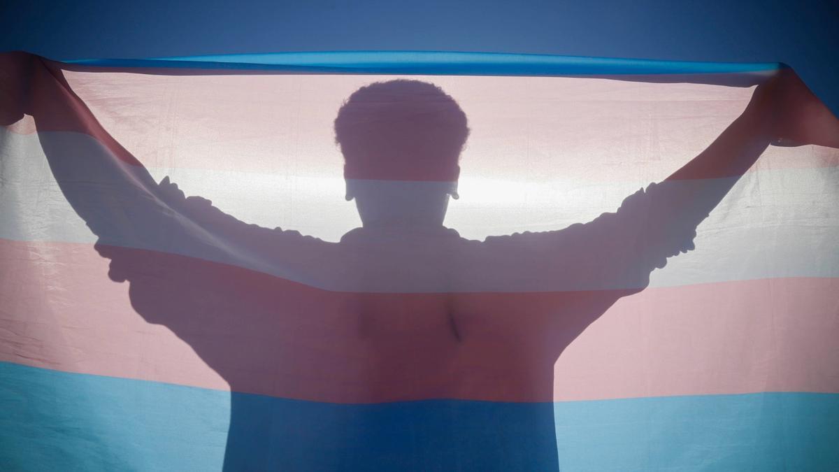 Una persona sostiene una bandera LGTB.