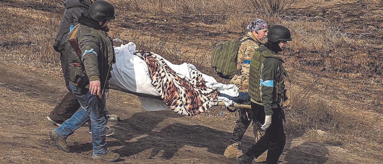Soldados ucranianos transportan un cadáver en Irpin, a las afueras de Kiev, el pasado sábado. REUTERS