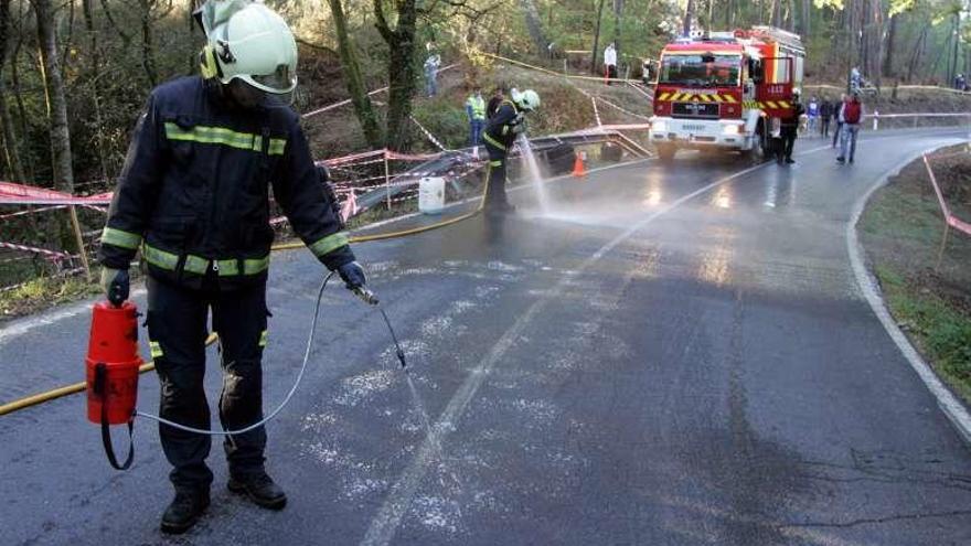 Efectivos de Emerxencias limpian el vertido de aceite en el trazado de la subida. // Bernabé/Luismy