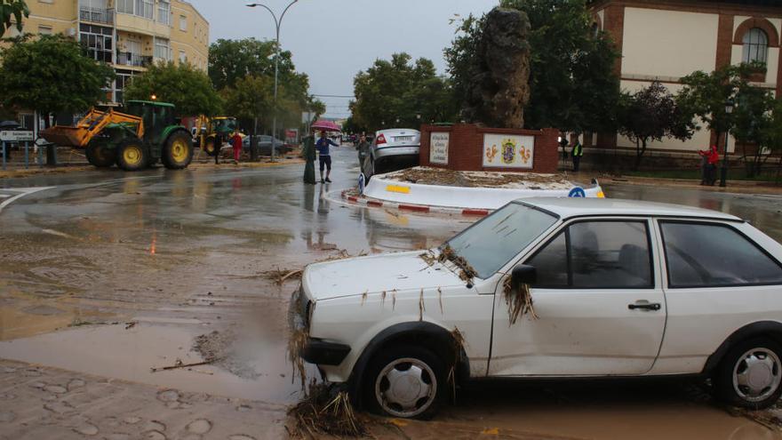 Un coche lleno de barro, debido a las intensas lluvias del 21 de octubre, en una rotonda de Campillos.