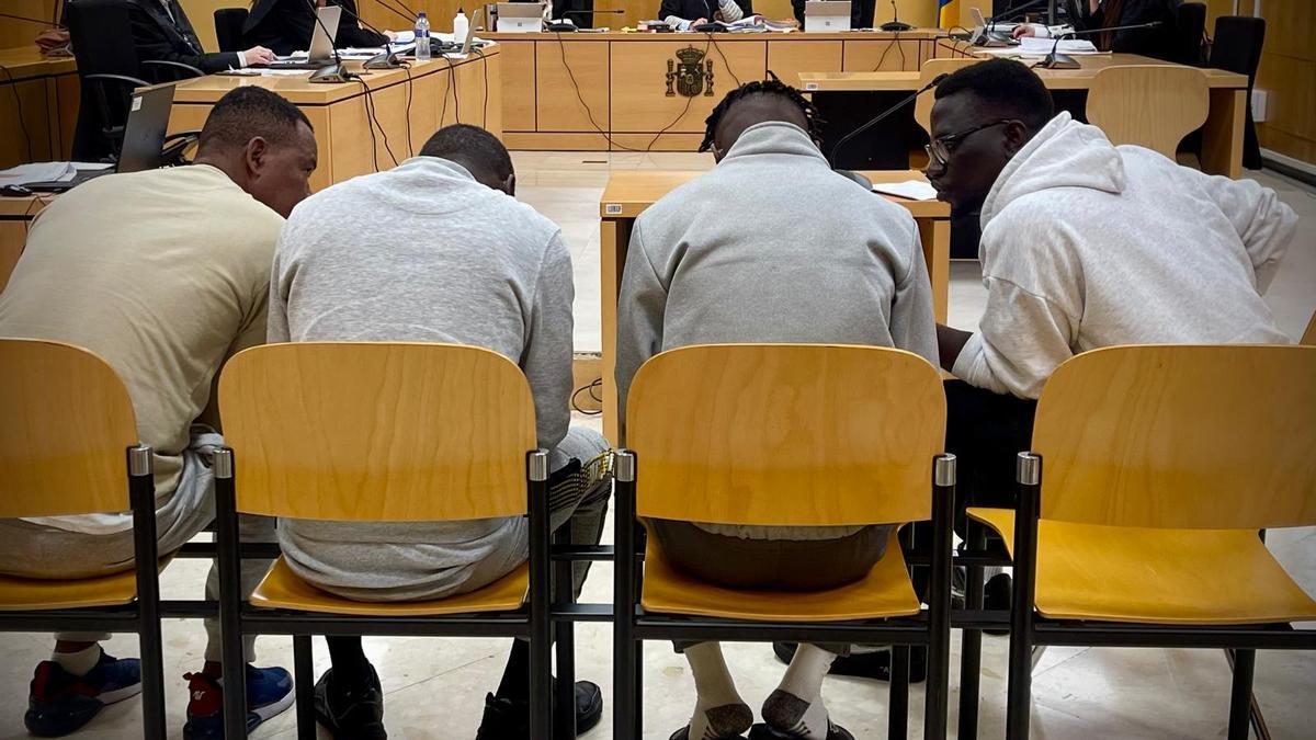 A la derecha el intérprete, junto a los tres acusados durante un momento del juicio.