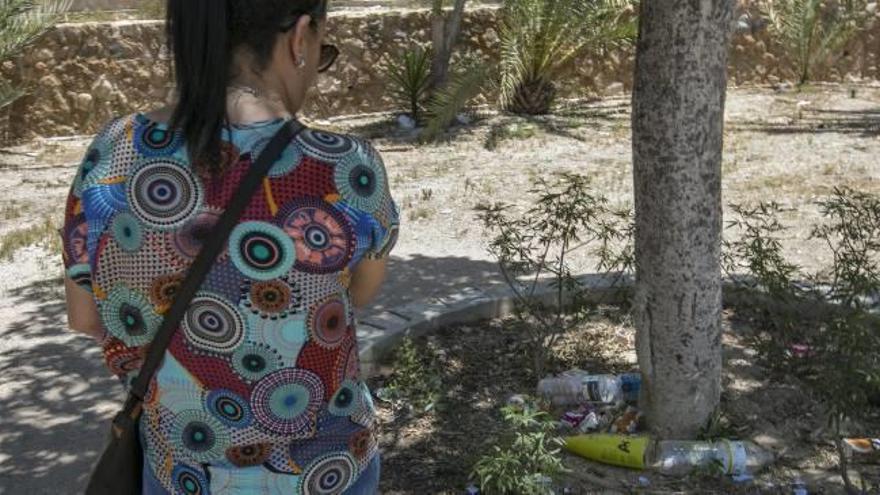 Una vecina de Portes Encarnades contempla la basura que se acumula en uno de los árboles.