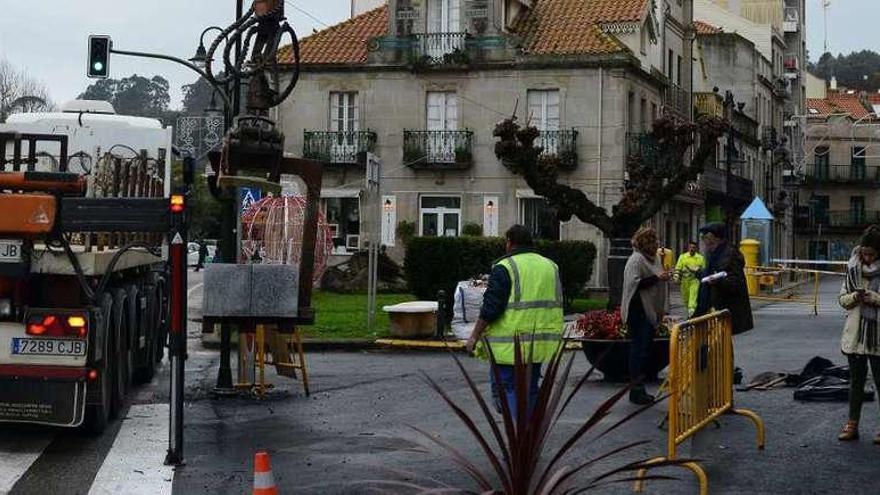 Operarios descargan los bancos de piedra en Méndez Núñez ayer a mediodía, donde se encontraban Giráldez, Pazos y Agulla. // G.N.