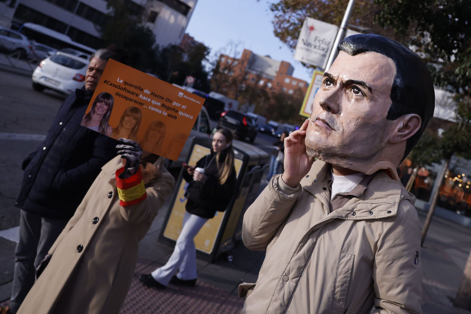 Una persona con una máscara de Pedro Sánchez entre el pequeño grupo que se ha concentrado este miércoles ante los Juzgados de Plaza de Castilla, donde el juez que investiga a Begoña Gómez, esposa del presidente del Gobierno, le toma declaración como investigada por los dos nuevos delitos que le imputó en relación a la contratación de un software de la cátedra que codirigió en la Universidad Complutense de Madrid (UCM). EFE/ Javier Lizón