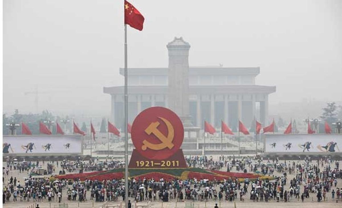 Els turistes es reuneixen al voltant d’un gegant emblema del Partit Comunista Xinès establert a la plaça de Tiananmen (Pequín), per celebrar el 90è aniversari de la formació política.
