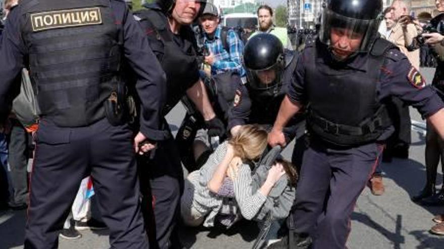 Agents de la policia, arrossegant dos manifestants.