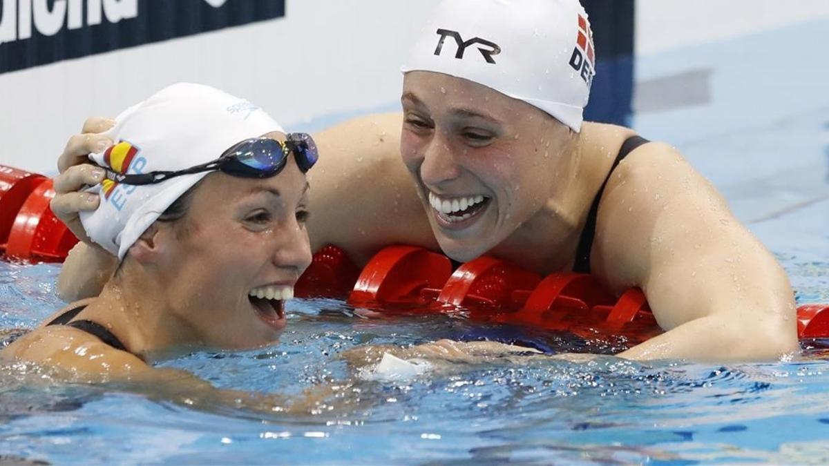 Jessica Vall (izquierda) es felicitada con cariño por Rikke Moeller Pedersen tras colgarse respectivamente la plata y el oro en los 200 metros braza en los Europeos de natación de Londres.