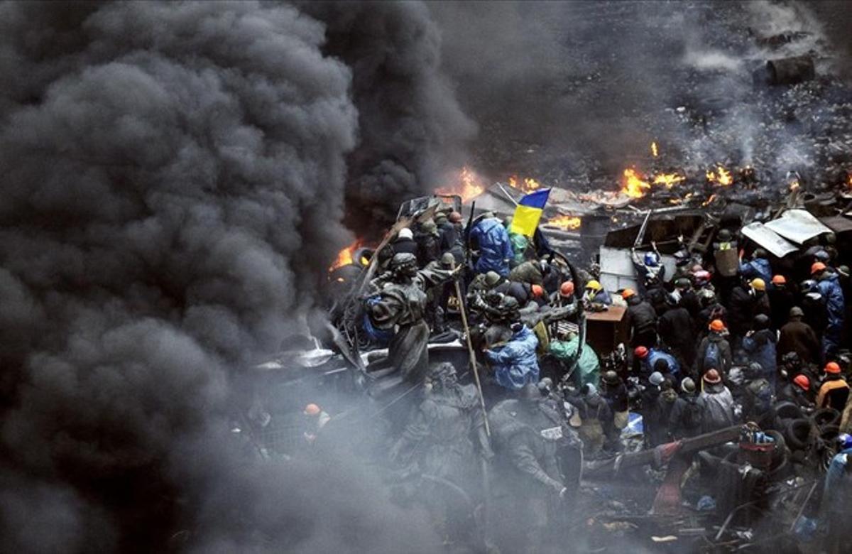 Manifestantes detrás de las barricadas durante los enfrentamientos contra la policía en Kiev.