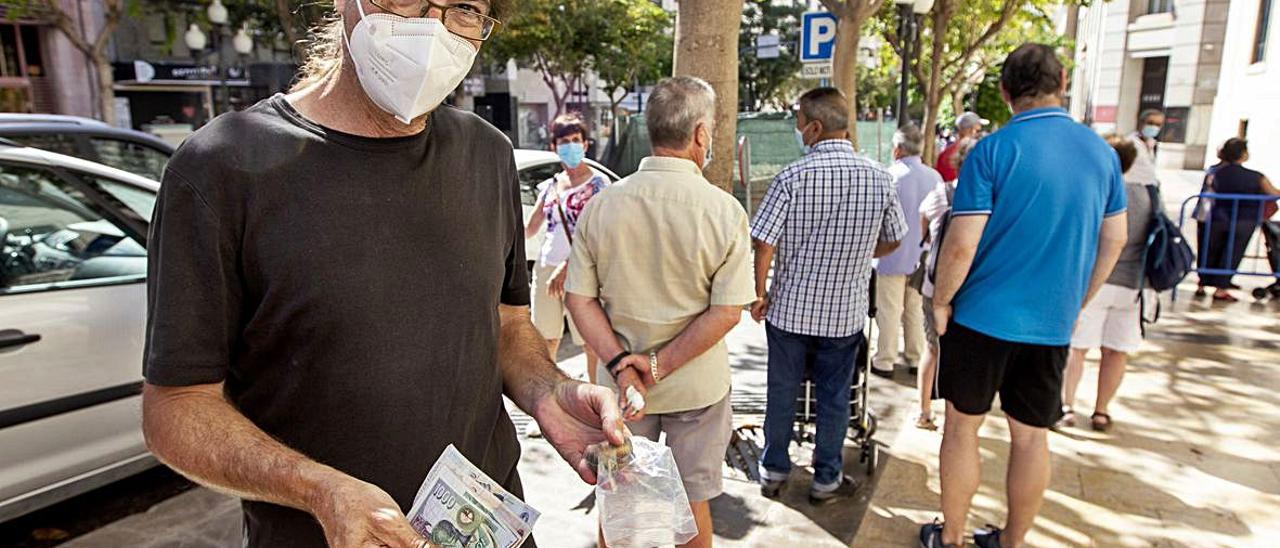 Miguel Barragán muestras las pesetas que le dio su padre, que las coleccionaba. A la derecha, Guillermo Poyatos, con los billetes que iba a cambiar para una amiga. | ALEX DOMÍNGUEZ