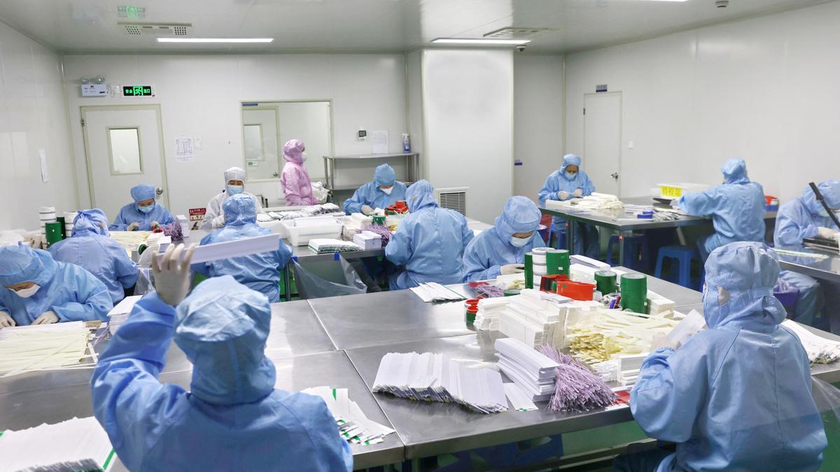 Workers work on manufacturing antigen testing kits for the COVID-19, at a workshop in Nantong