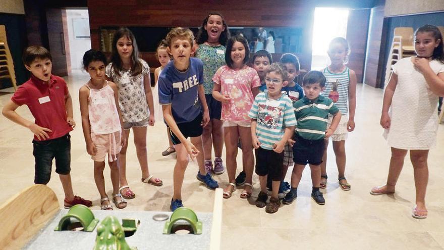 Uno de los niños pone a prueba su puntería con la rana.