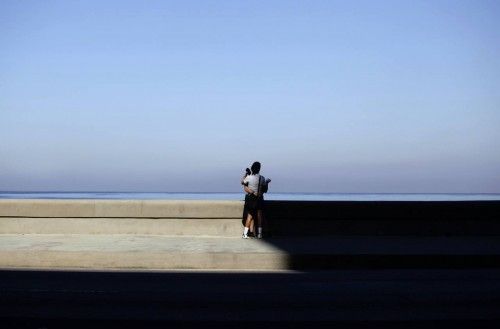 A couple stand on Havana's seafront boulevard "El Malecon"