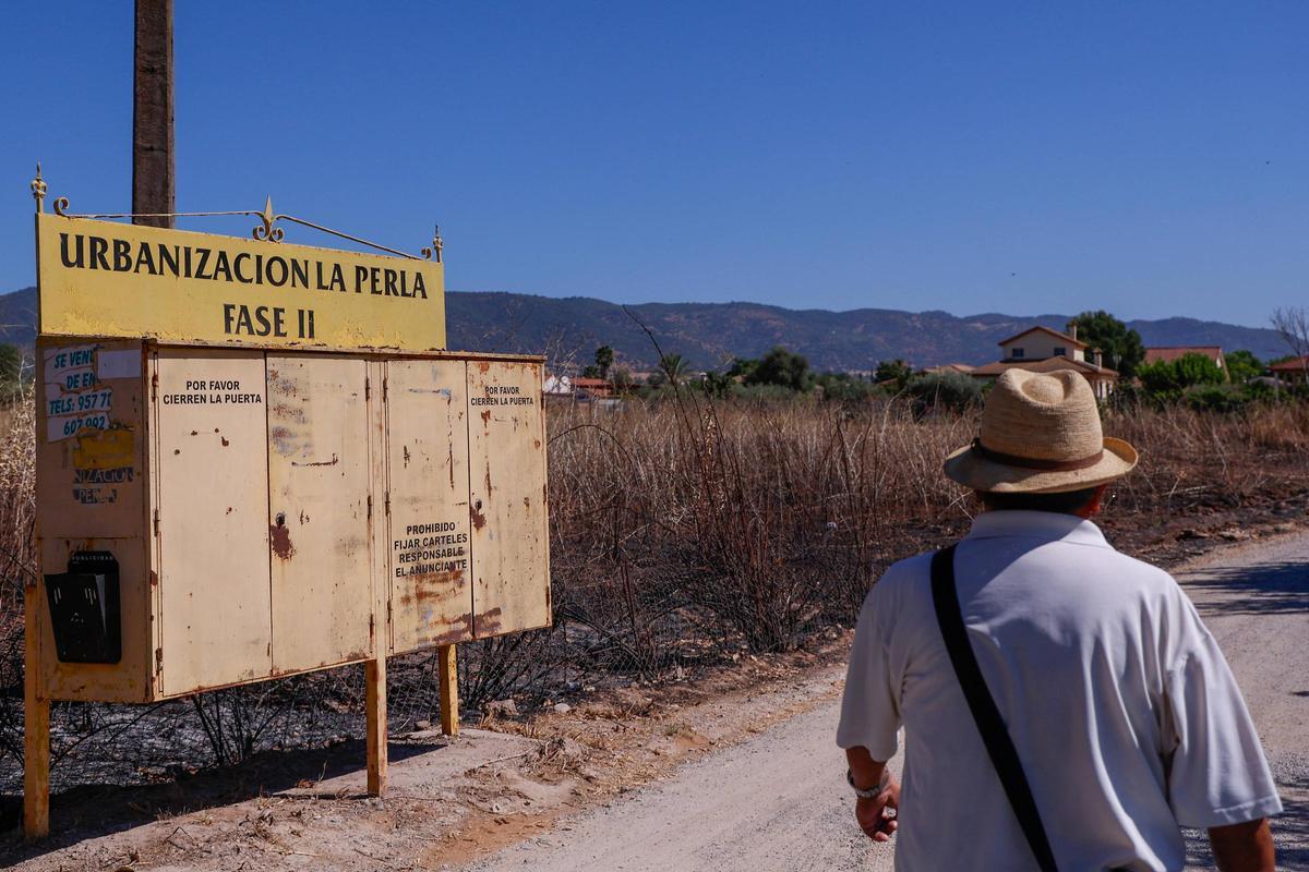 Un vecino pasea por la urbanización de La Perla II.