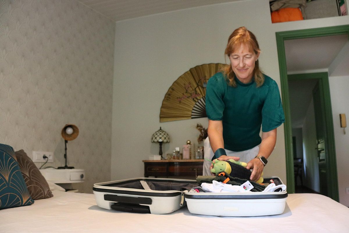 Isabel, mare d'acollida, preparant una maleta per anar-se'n de vacances a Llafranc amb el menor que acull.
