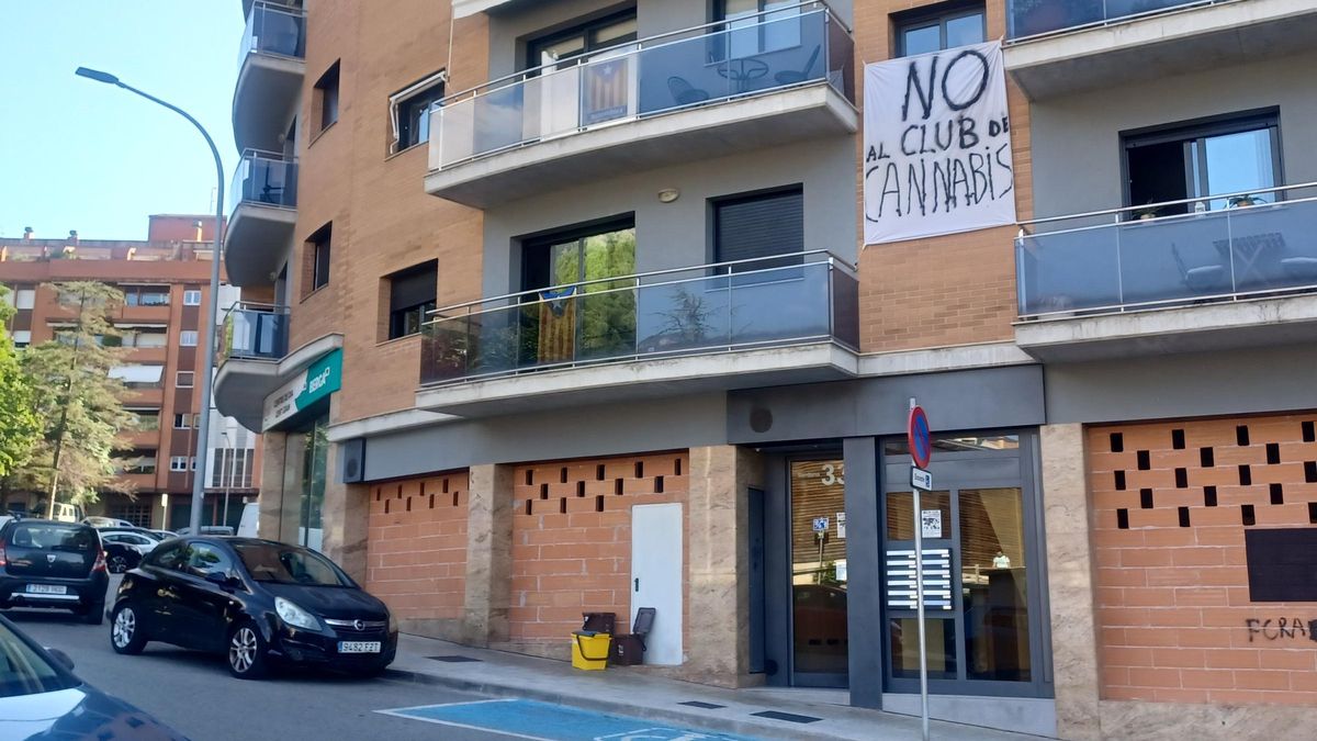Pancarta al bloc on es plantegen ubica un club cannàbic, als baixos