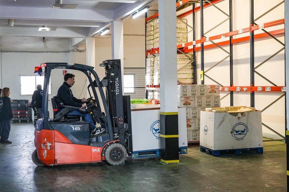 Un voluntario del Banco de Alimentos de Badajoz transporta una caja con productos en su almacén de El Nevero.