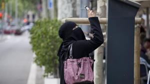 Una imagen de archivo de una mujer musulmana con burka niqab sacando fotos en el Paseo de Gràcia de Barcelona.