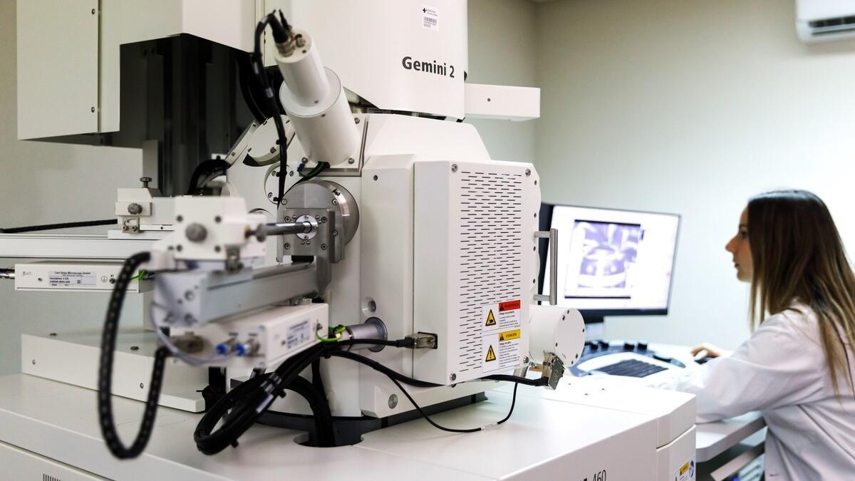 Una investigadora ante un microscopio electrónico para observar biopsias
