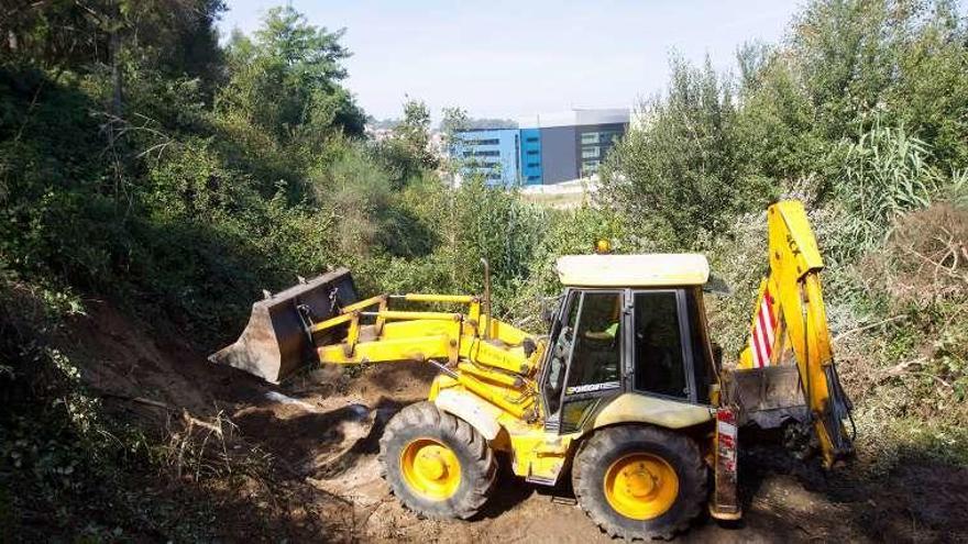 Una operario retira tierras con una pala en la parcela. // R. Grobas