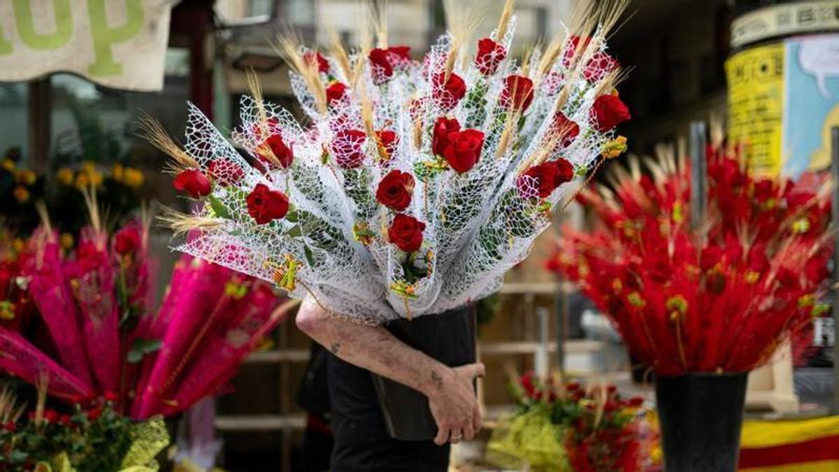 Un hombre con rosas decenas de rosas rojas el día de Sant Jordi 2024.
