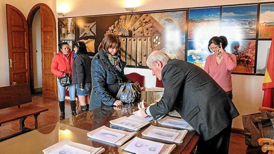 Membres de l&#039;equip de govern repartint els xecs per a llibres de text