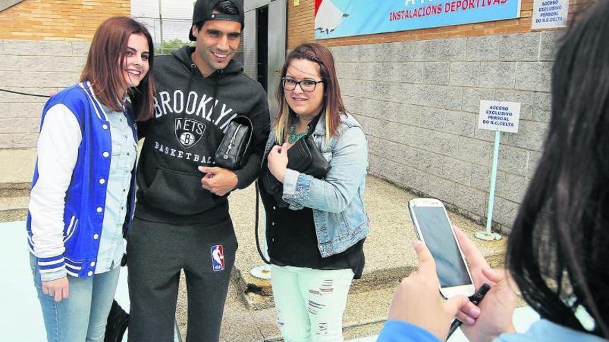 Augusto Fernández se fotografía con dos aficionadas tras el entrenamiento de ayer en A Madroa.  // Santomé