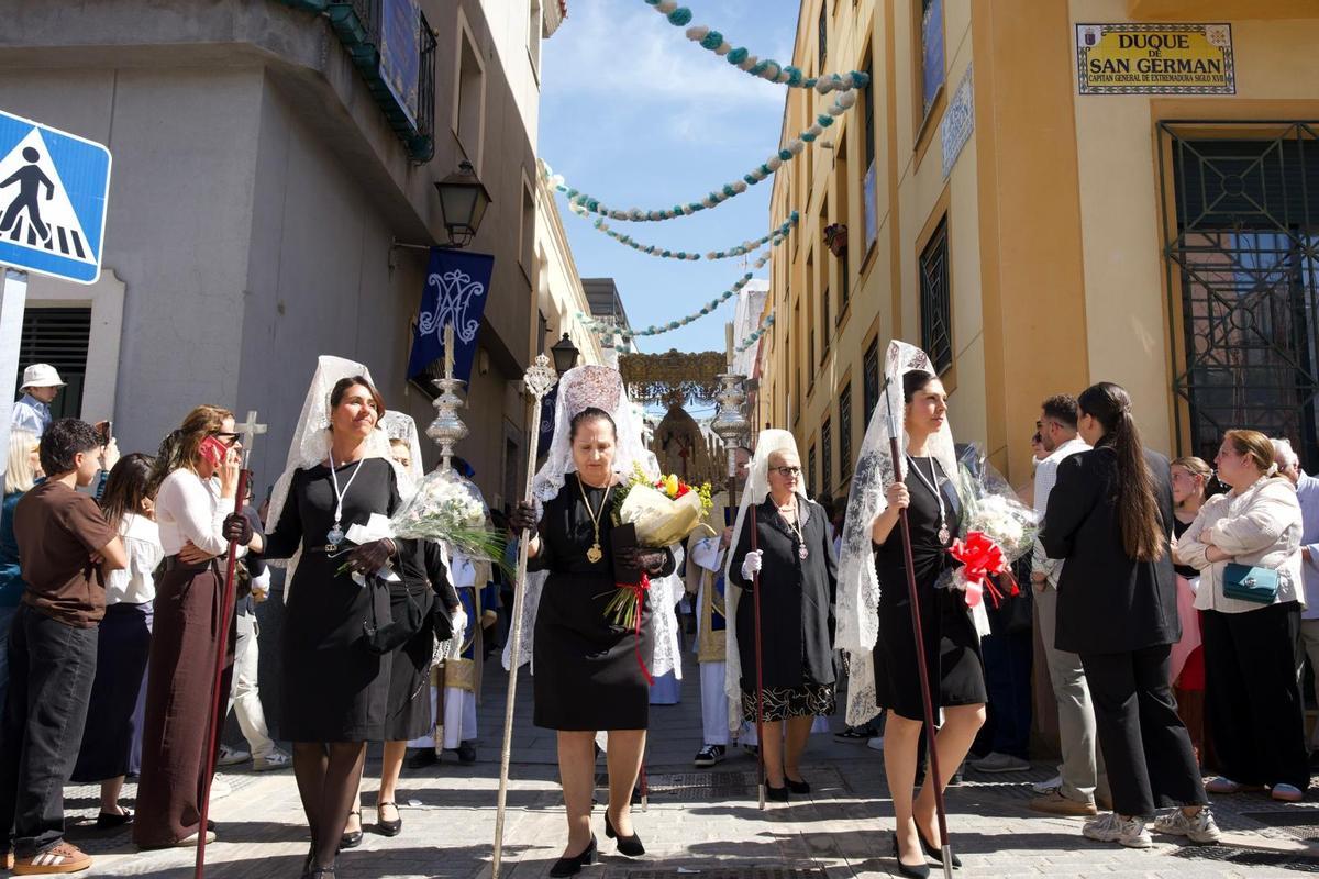 Mujeres de mantilla acompañan el paso de la Virgen por la calle Duque de San Germán.