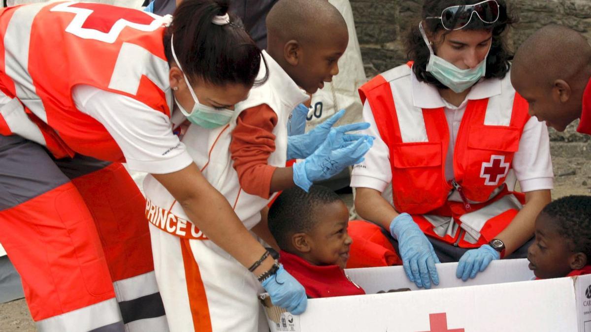 Voluntarios de Cruz Roja, con niños.