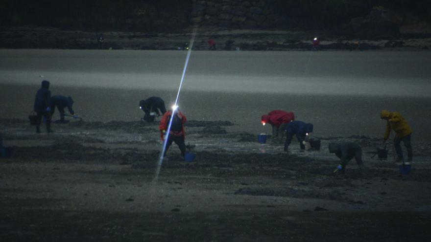Las mariscadoras con las luces en la cabeza para alumbrar en el mar. |