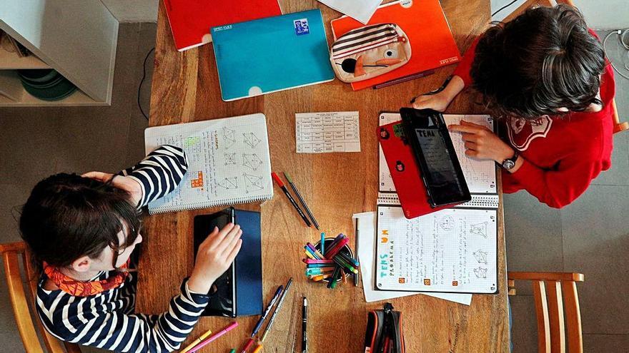 Dos escolares de Primaria estudian en casa, por la suspensión de clases.