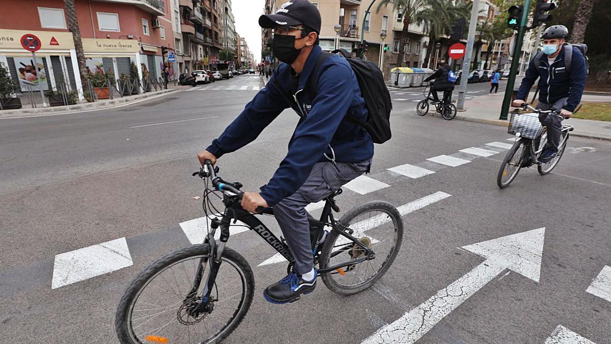 Tres usuarios de la bicicleta en un punto del casco urbano de Elche. | ANTONIO AMORÓS