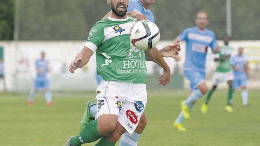 Acoirán, del Coruxo, presiona a un jugador del Atlético Astorga durante el encuentro de ayer en La Eragudina. // Diario de León