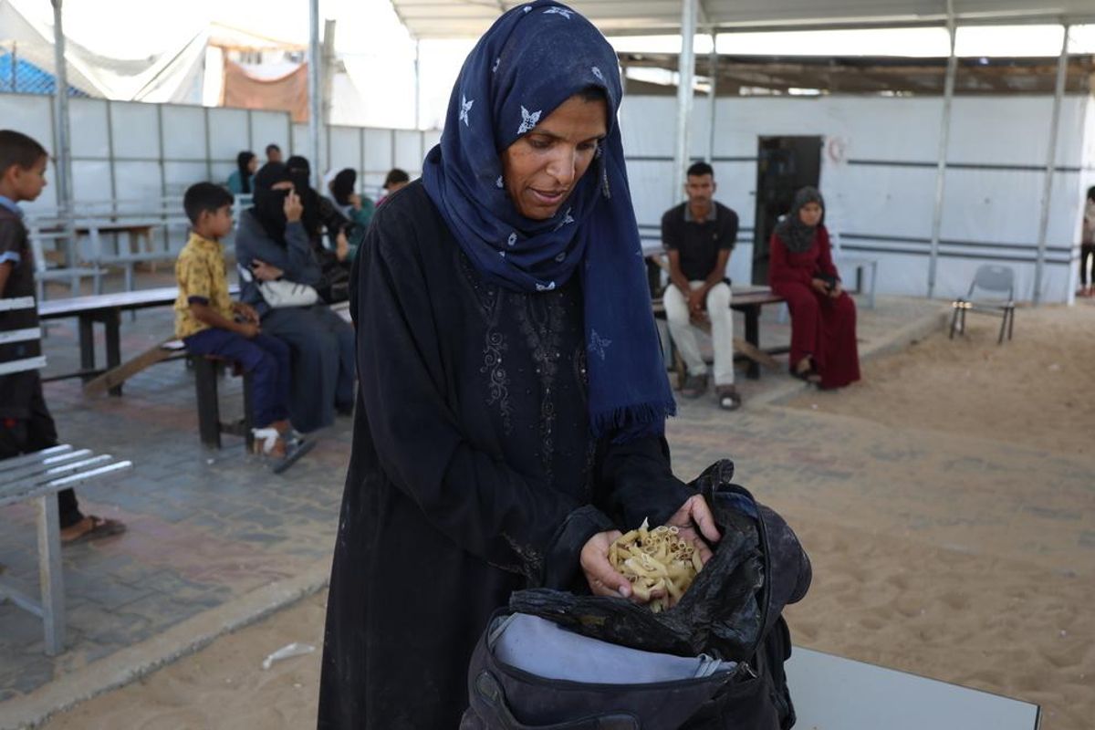 Samah Hamdan, una mujer palestina desplazada, recogiendo algo de comida para su familia.