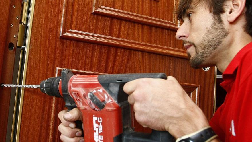 Un empleado de una empresa de seguridad, instalando una puerta blindada.