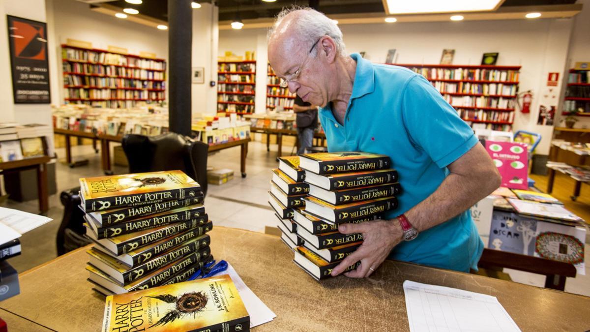 Josep Cots desembala los libros de 'Harry Potter y el legado maldito' en la librería Documenta.