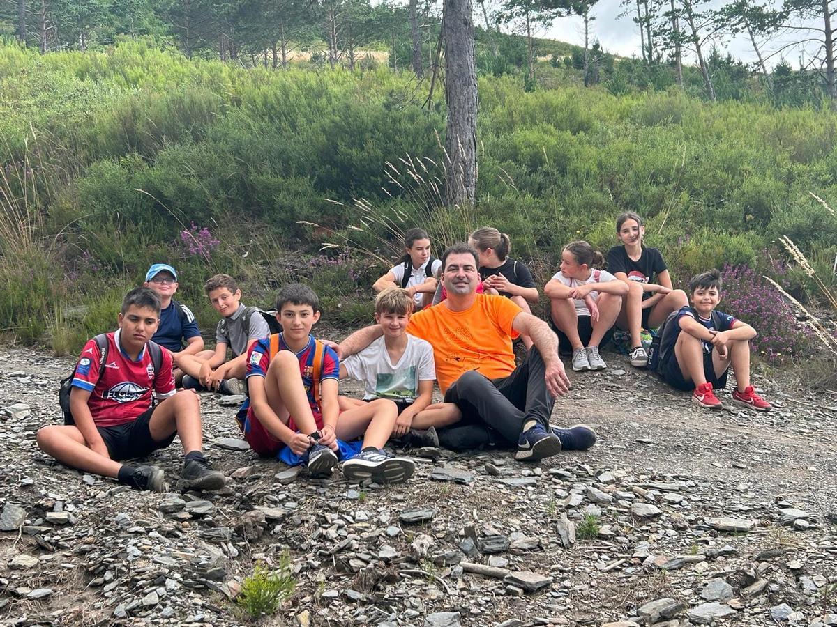 Algunos niños descansan junto al alcalde, Sergio Hidalgo,  en el transcurso de la ruta