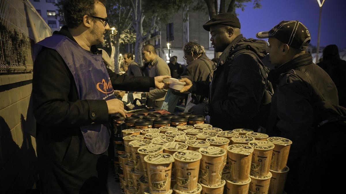 Miembros de Amásdes reparten tres días a la semana comida caliente a unas 200 personas en la Estació del Nord.