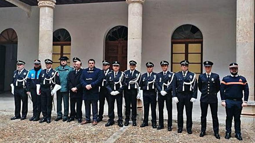 En la parte superior, autoridades posan con los agentes en activo de la Policía Local y con responsables de otros cuerpos de seguridad de la ciudad. En la imagen de la izquierda, los policías custodian a la imagen del patrón portada por cofrades durante la procesión.